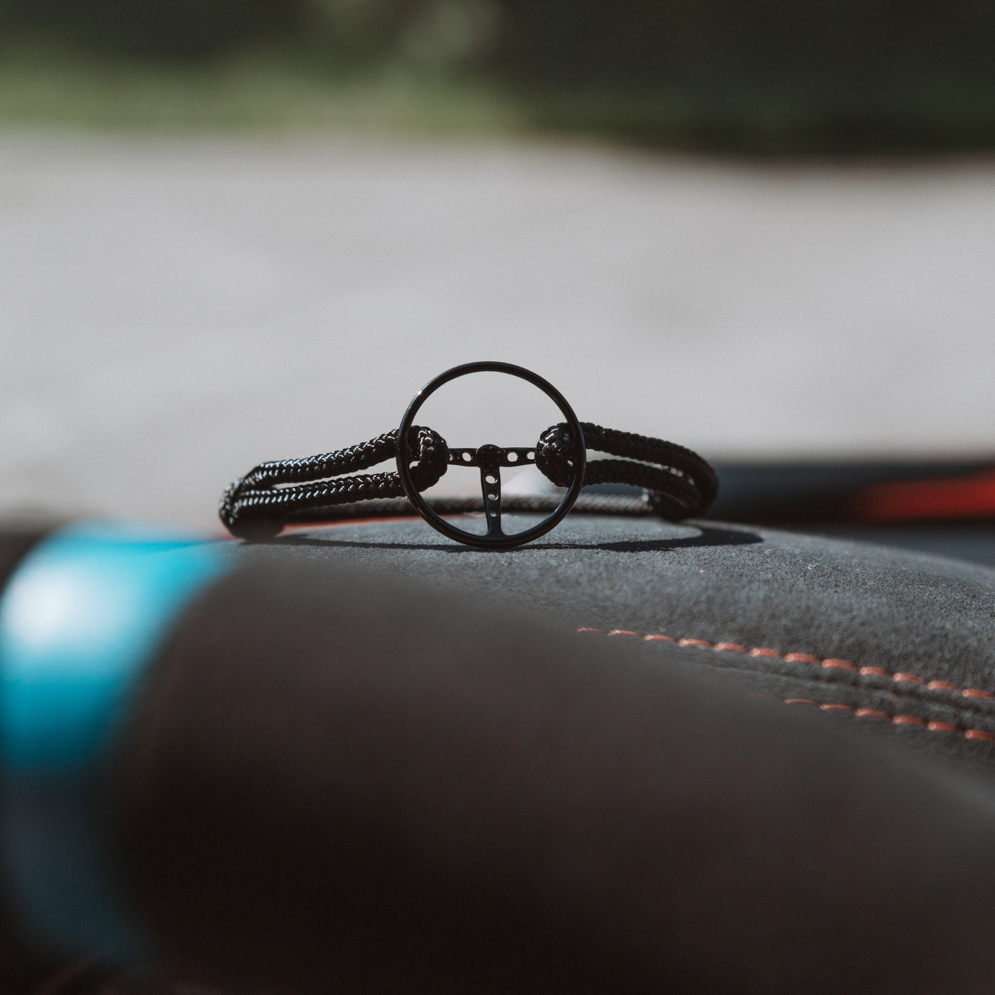 Classic Steering Wheel Bracelet laying on leather.