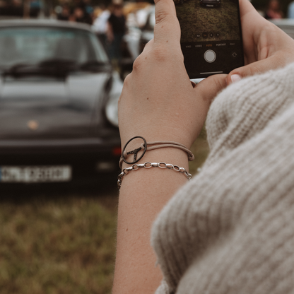 Woman is wearing the Classic Steering Wheel Bracelet. Holding an Iphone.